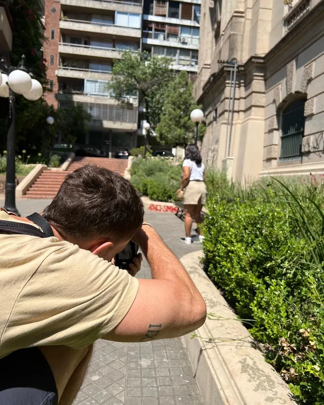 Santi filmando en la calle, agachado con la cámara